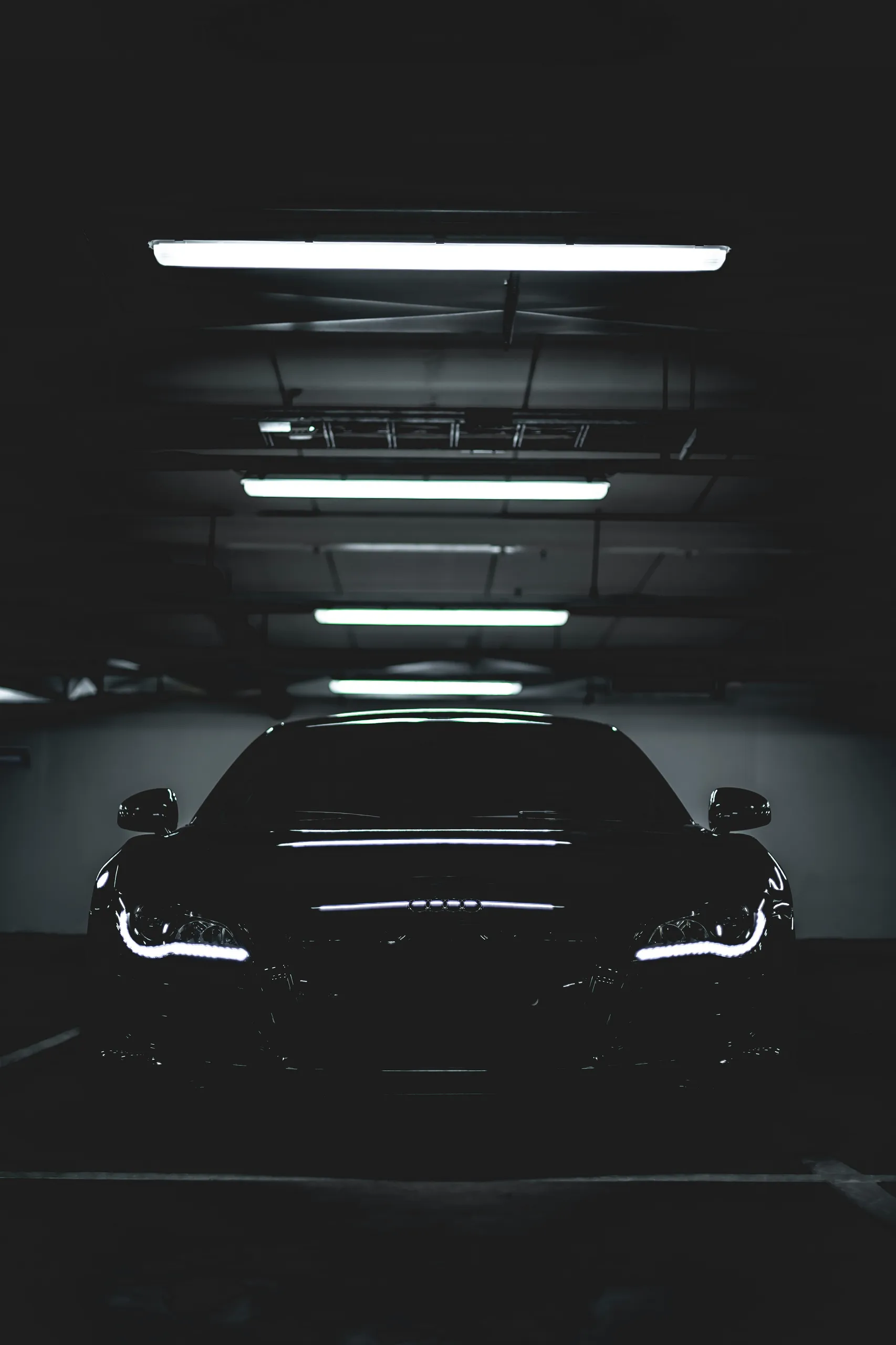 Audi R8 negro con pintura profunda en la nave, fuertes reflejos de luz